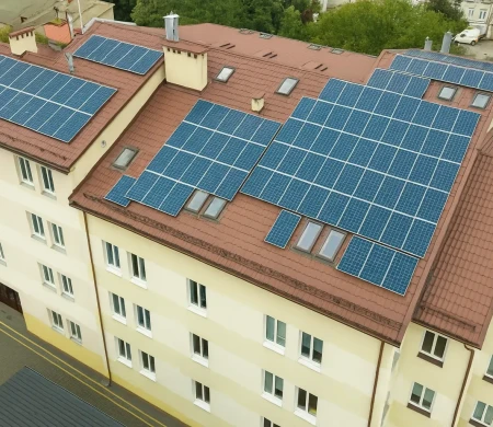 bytový dům s instalovanými fotovoltaickými panely na střeše, pohled z dronu